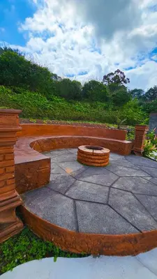 a stone patio with a fire pit in a park at Confort Arenal in Fortuna