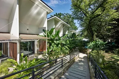 a house with a staircase leading up to a house at NATURA Loft Garden in Santa Teresa Beach