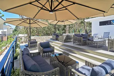 a patio with chairs and tables and umbrellas at NATURA Loft Garden in Santa Teresa Beach