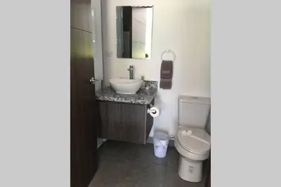 a bathroom with a white toilet and a sink at 2BR Condominium in Downtown Jaco in Jacó