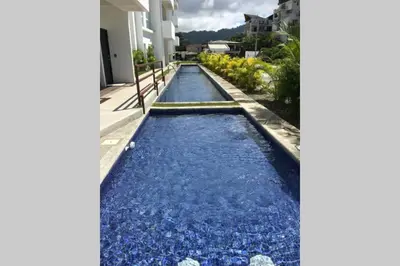 a pool of water with blue rocks in the middle at 2BR Condominium in Downtown Jaco in Jacó