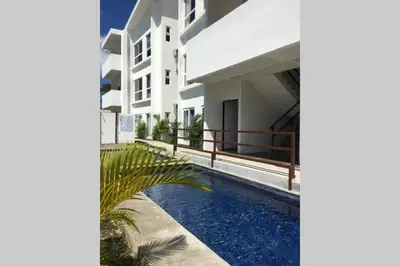 a villa with a swimming pool in front of a building at 2BR Condominium in Downtown Jaco in Jacó