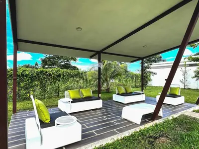a gazebo with four white chairs and yellow pillows at 2BR Condominium in Downtown Jaco in Jacó