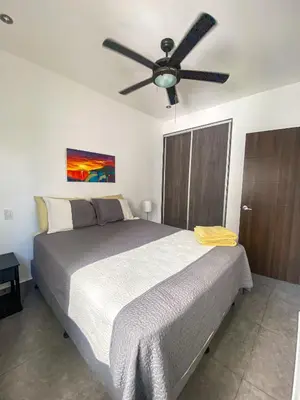 a bedroom with a bed with a ceiling fan at 2BR Condominium in Downtown Jaco in Jacó