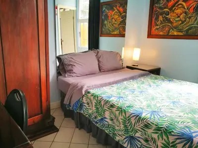 a small bedroom with a bed with a colorful comforter at Hotel Casa 69 in San José