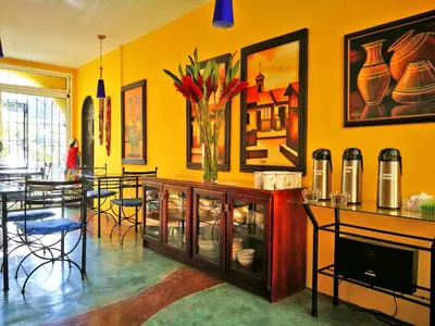 a dining room with yellow walls and a table with chairs at Hotel Casa 69 in San José