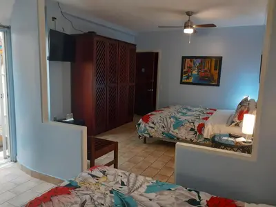 a bedroom with two beds and a mirror at Hotel Casa 69 in San José