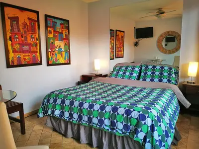 a bedroom with a bed with a blue and green comforter at Hotel Casa 69 in San José