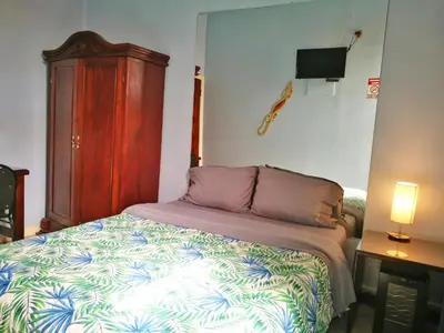 a bedroom with a bed and a tv on the wall at Hotel Casa 69 in San José