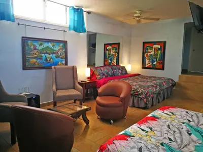 a bedroom with a bed and a couch and a chair at Hotel Casa 69 in San José