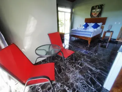 a room with a table and chairs and a bed at Tuki Tuki Lodge in Sámara