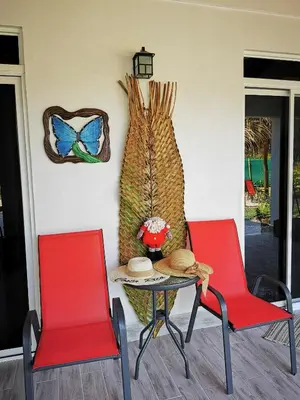 two red chairs and a table in a room at Tuki Tuki Lodge in Sámara