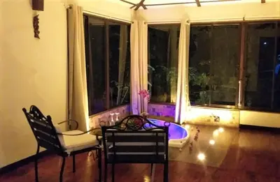 a room with a table and chairs and a large window at Tropical Suites & Villas in Fortuna