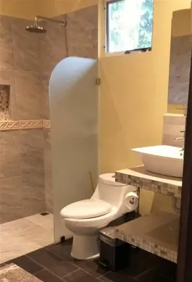 a bathroom with a toilet and a sink at Tropical Suites & Villas in Fortuna