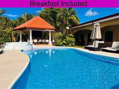 a swimming pool in front of a house at Las Brisas Resort and Villas in Jacó