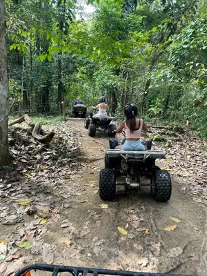 two people riding atvs down a dirt road at Las Brisas Resort and Villas in Jacó