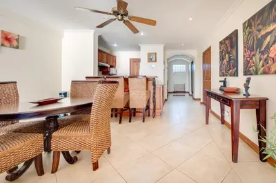 a dining room with a table and chairs and a ceiling fan at Oceanica 804 in Playa Flamingo