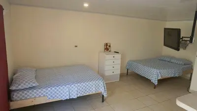 a bedroom with two beds and a dresser in it at Apartamento Equipado Morpho CR. in Quepos