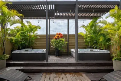 a bathroom with two soaking tubs and palm trees at Grano de Oro Hotel in San José