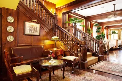 a living room with wood paneling and a staircase at Grano de Oro Hotel in San José