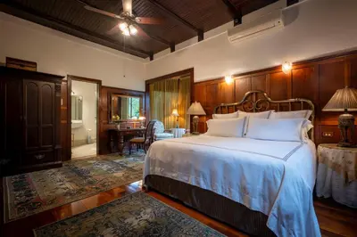 a bedroom with a large bed and a dining room at Grano de Oro Hotel in San José