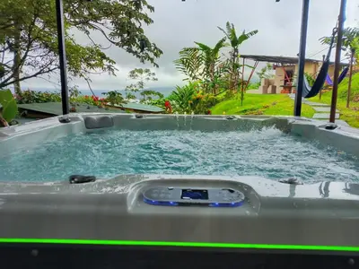 a jacuzzi tub with water in a yard at Essence Arenal Spa & Yoga in El Castillo de La Fortuna