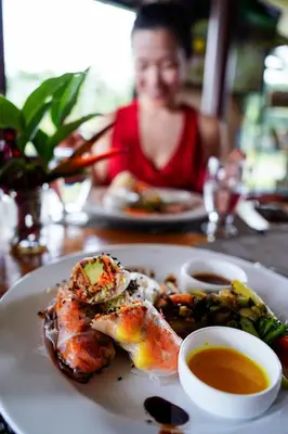 a woman sitting at a table with a plate of food at Essence Arenal Spa & Yoga in El Castillo de La Fortuna