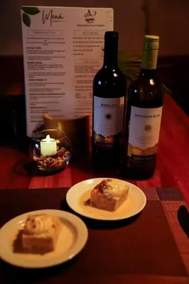 a table with two plates of food and two bottles of wine at Essence Arenal Spa & Yoga in El Castillo de La Fortuna