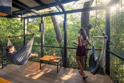 a man and a woman in hammocks on a deck at Rio Perdido Hotel & Thermal River in Fortuna