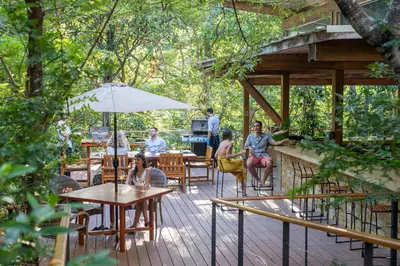 a group of people sitting at tables on a deck at Rio Perdido Hotel & Thermal River in Fortuna