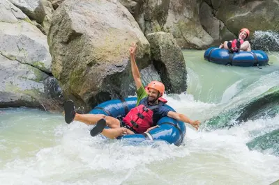 two people are rafting down a waterfall on a river at Rio Perdido Hotel & Thermal River in Fortuna
