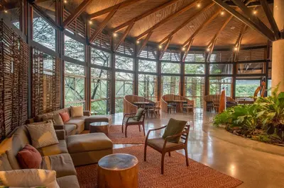 a living room with a large glass wall at Rio Perdido Hotel & Thermal River in Fortuna
