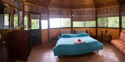 a bedroom with a bed in a room with windows at Hotel Vista de Olas in Santa Teresa Beach