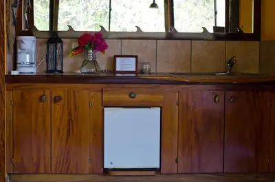 a kitchen with a counter with a white refrigerator under it at Hotel Vista de Olas in Santa Teresa Beach