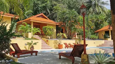 a group of chairs and a street light next to a house at Hotel Ritmo Tropical - Pool and Breakfast in Santa Teresa Beach