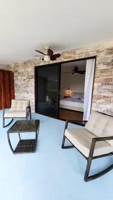 a living room with two chairs and a bed at La Puesta del Sol B&B in Carrillo