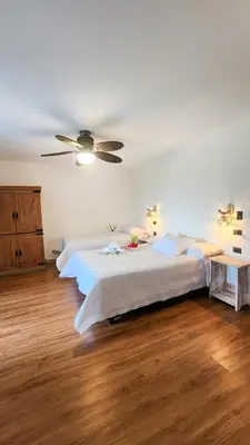 a bedroom with two beds and a ceiling fan at La Puesta del Sol B&B in Carrillo