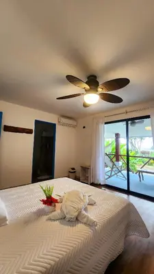 a bedroom with a large bed with a ceiling fan at La Puesta del Sol B&B in Carrillo