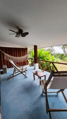 a room with a hammock and a chair and a table at La Puesta del Sol B&B in Carrillo