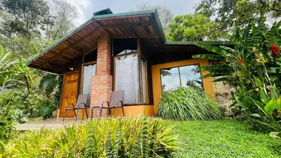 a small house with two chairs on a deck at El Toucanet Lodge & Restaurante in El Copey