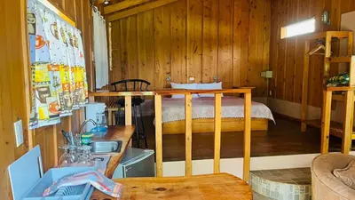 a bedroom with a bed in a wooden room at El Toucanet Lodge & Restaurante in El Copey