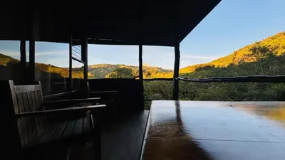 a porch of a building with a view of the mountains at El Toucanet Lodge & Restaurante in El Copey