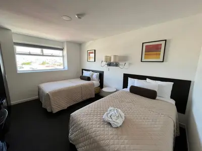 a hotel room with two beds and a window at Apartahotel Altos de la Sabana in San José