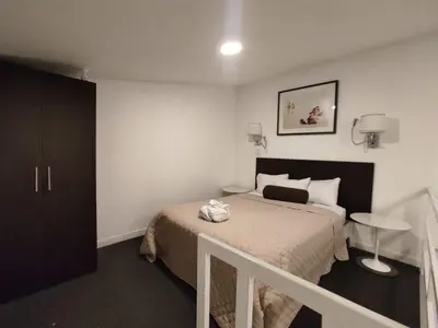 a hotel room with a bed and a staircase at Apartahotel Altos de la Sabana in San José