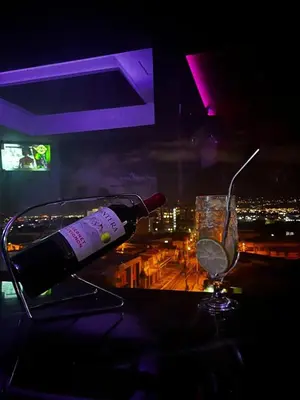 a bottle of wine sitting on a table with a glass at Apartahotel Altos de la Sabana in San José