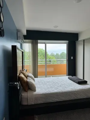 a bedroom with a bed and a large window at Cozy apartment near to Costa Rica Airport in Heredia