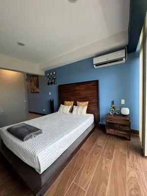 a bedroom with a large bed and a blue wall at Cozy apartment near to Costa Rica Airport in Heredia