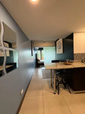 a kitchen with a counter and a table in a room at Cozy apartment near to Costa Rica Airport in Heredia