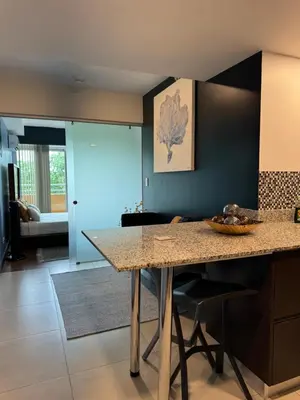 a kitchen with a counter and a table in a room at Cozy apartment near to Costa Rica Airport in Heredia