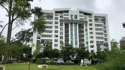 a tall white building with trees in front of it at Cozy apartment near to Costa Rica Airport in Heredia